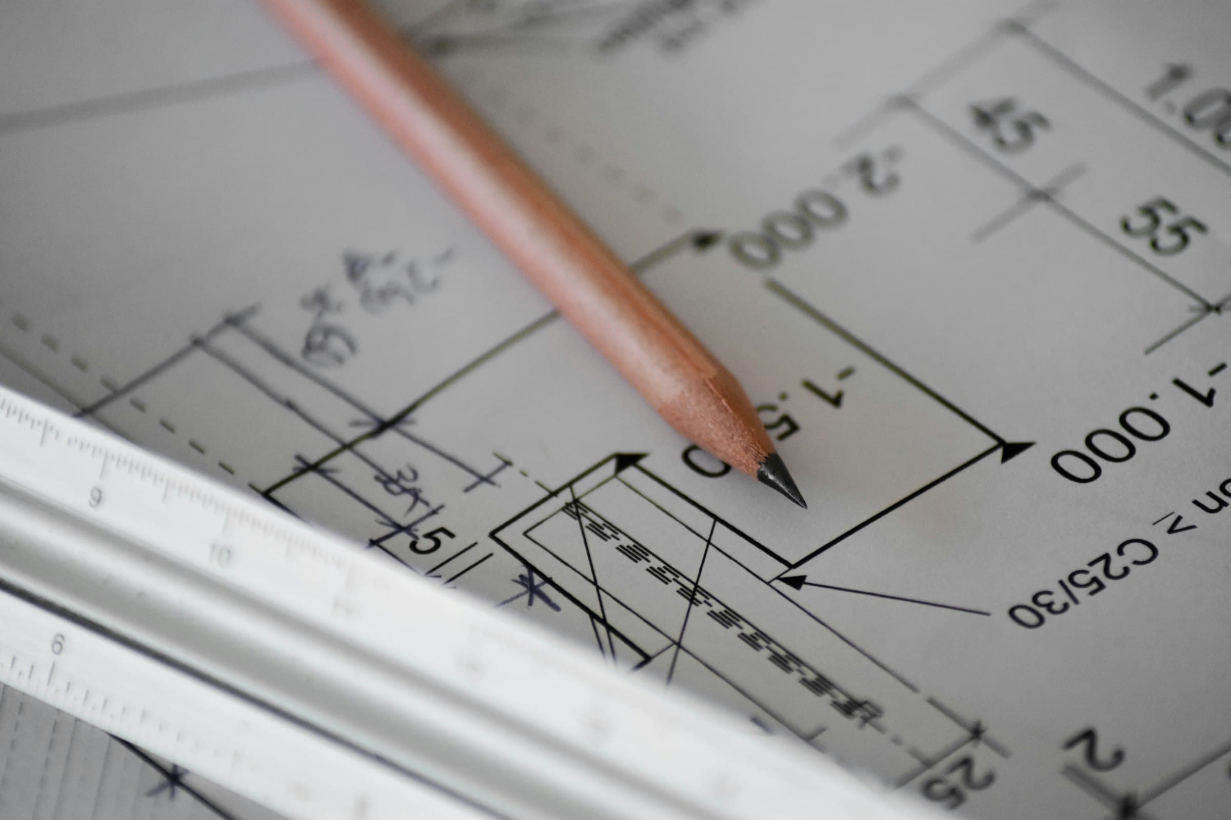 Pencil resting on a dimensioned engineering drawing