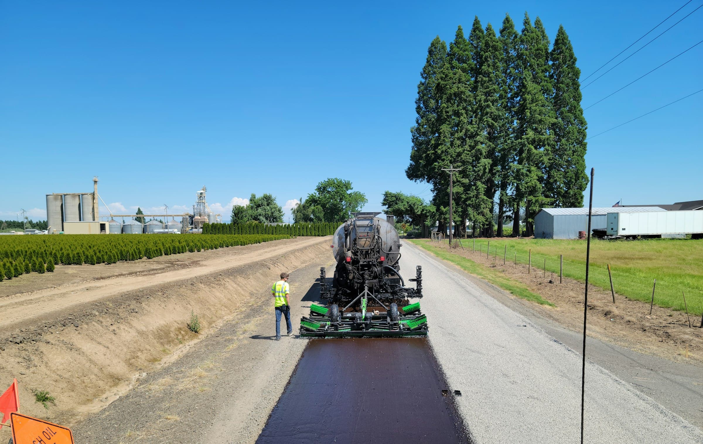 Paving machine laying fresh asphalt on a rural road