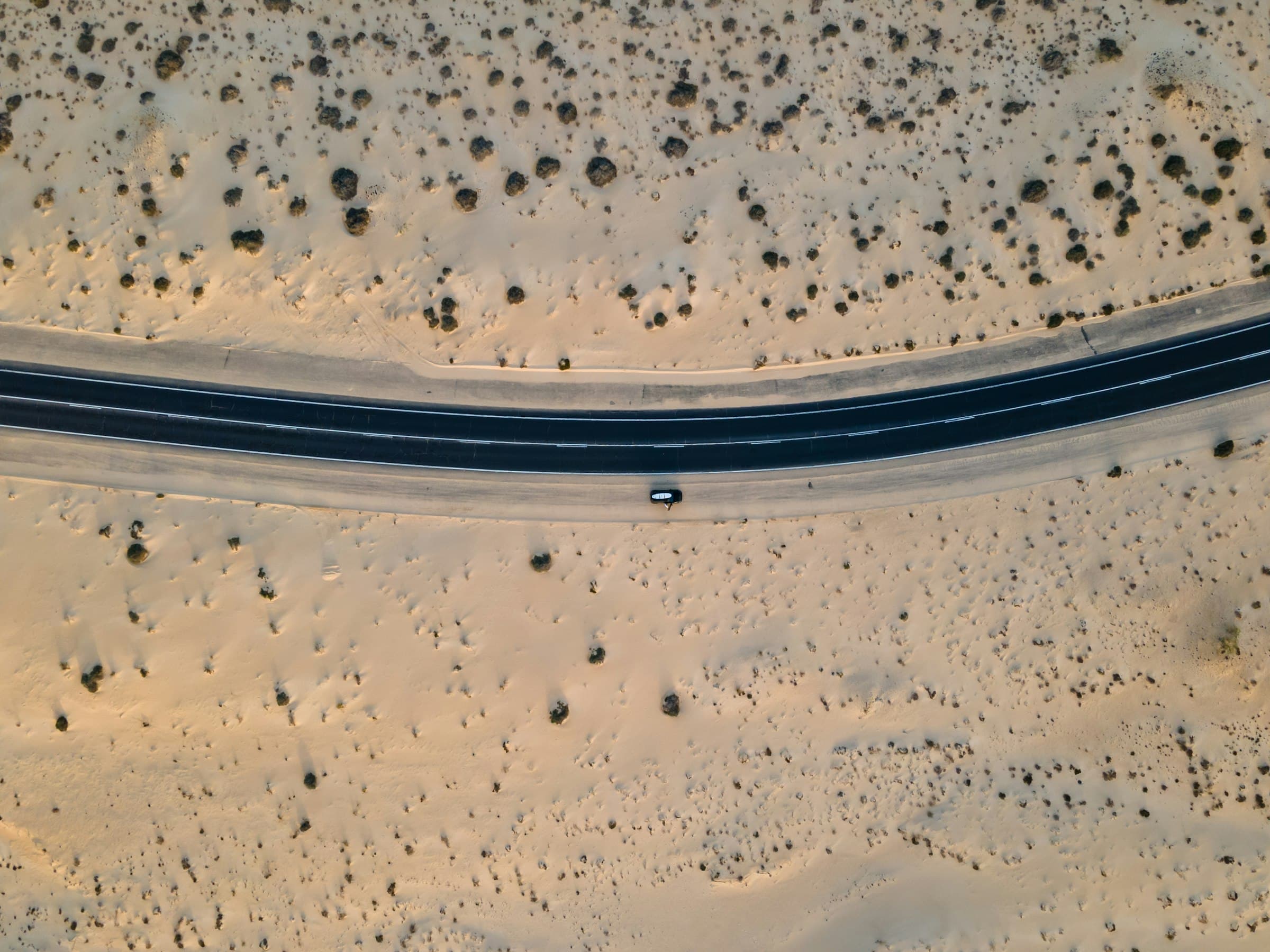 Road crossing open desert, seen from directly above
